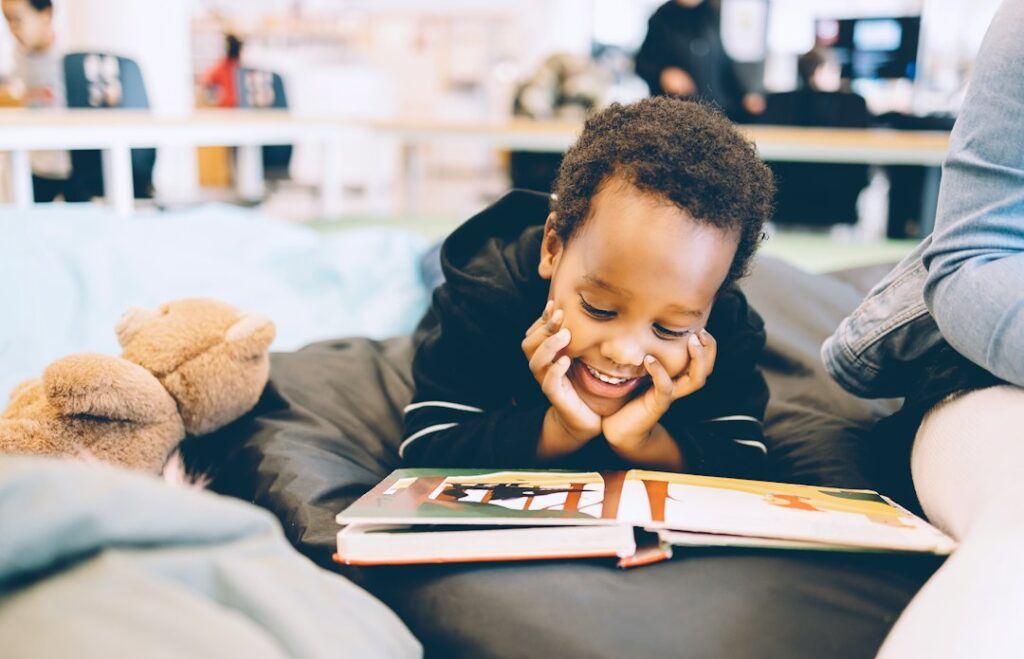 A smiling boy reading a book, representing engaging moral stories and memorable life lessons for children