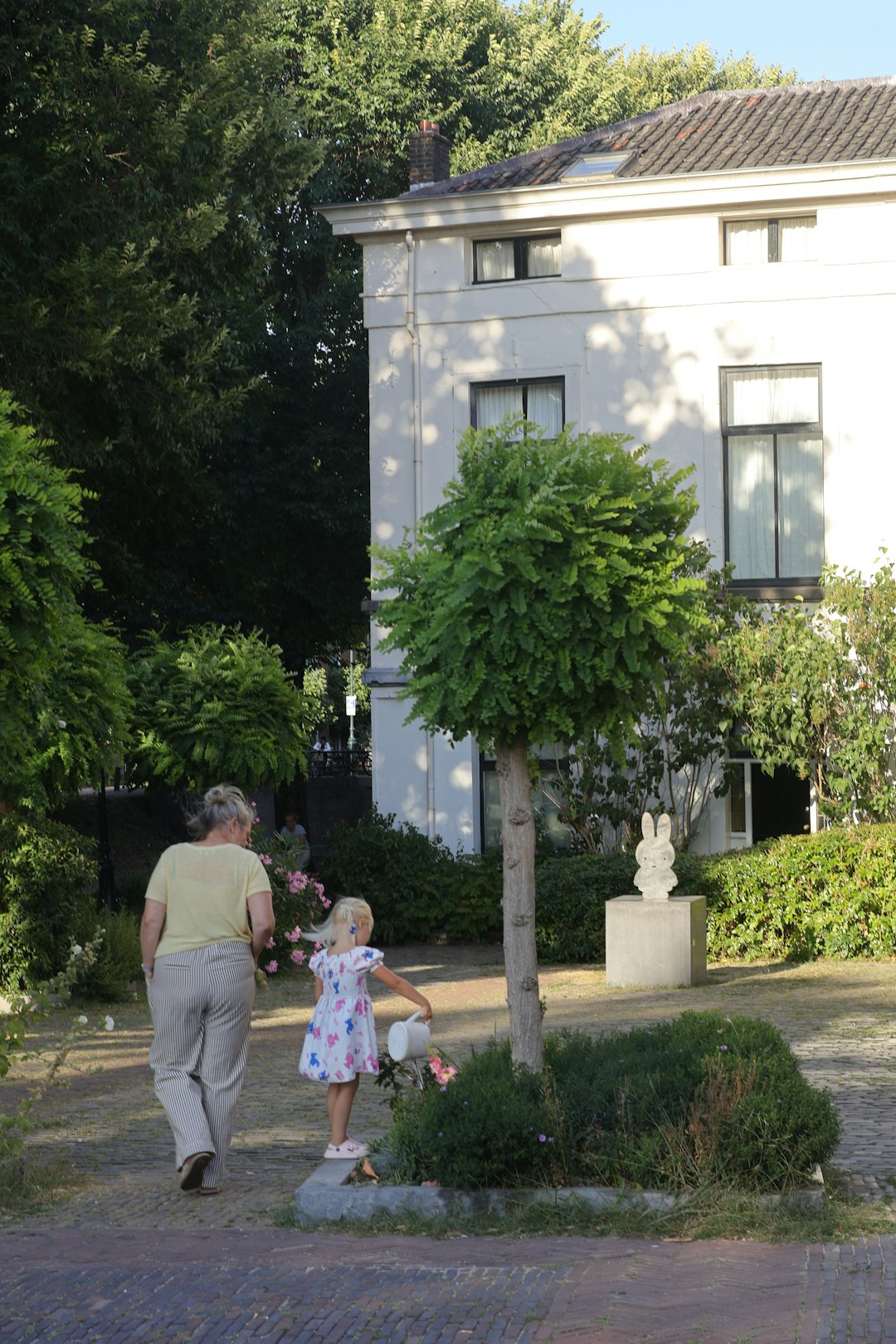 Adult and child walking in a garden